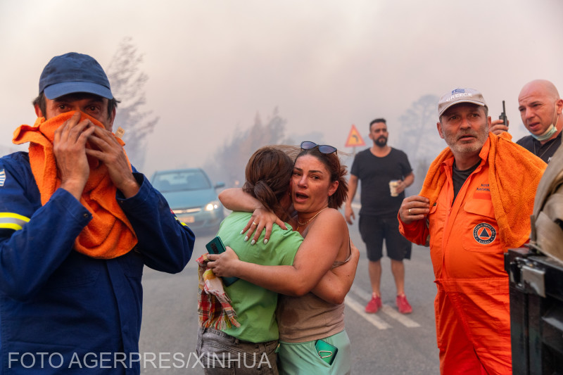 ATHENS, Aug. 12, 2024 (Xinhua) -- Local residents and firefighters are seen at the site of a wildfire in Varnavas, around 35 km from Athens, Greece, on Aug. 11, 2024.